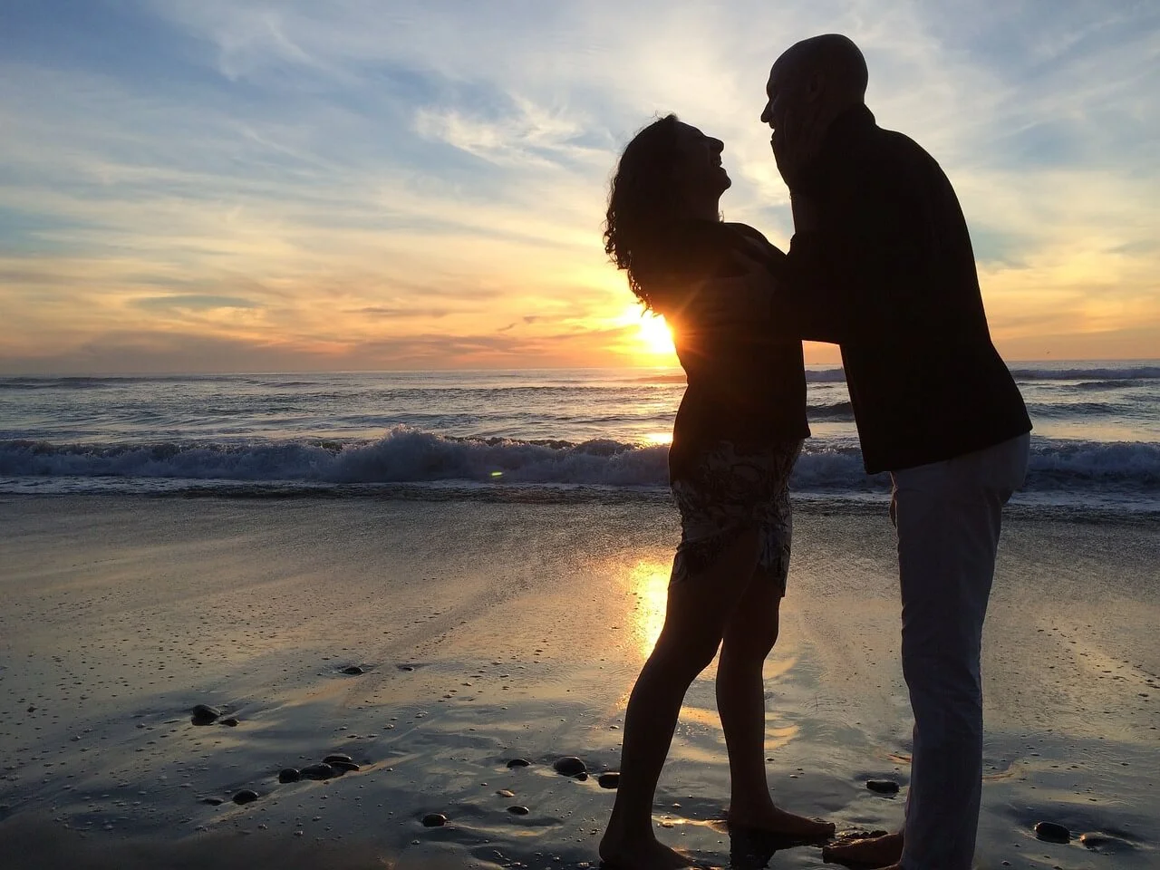 Paar genießt romantischen Sonnenuntergang am Strand.