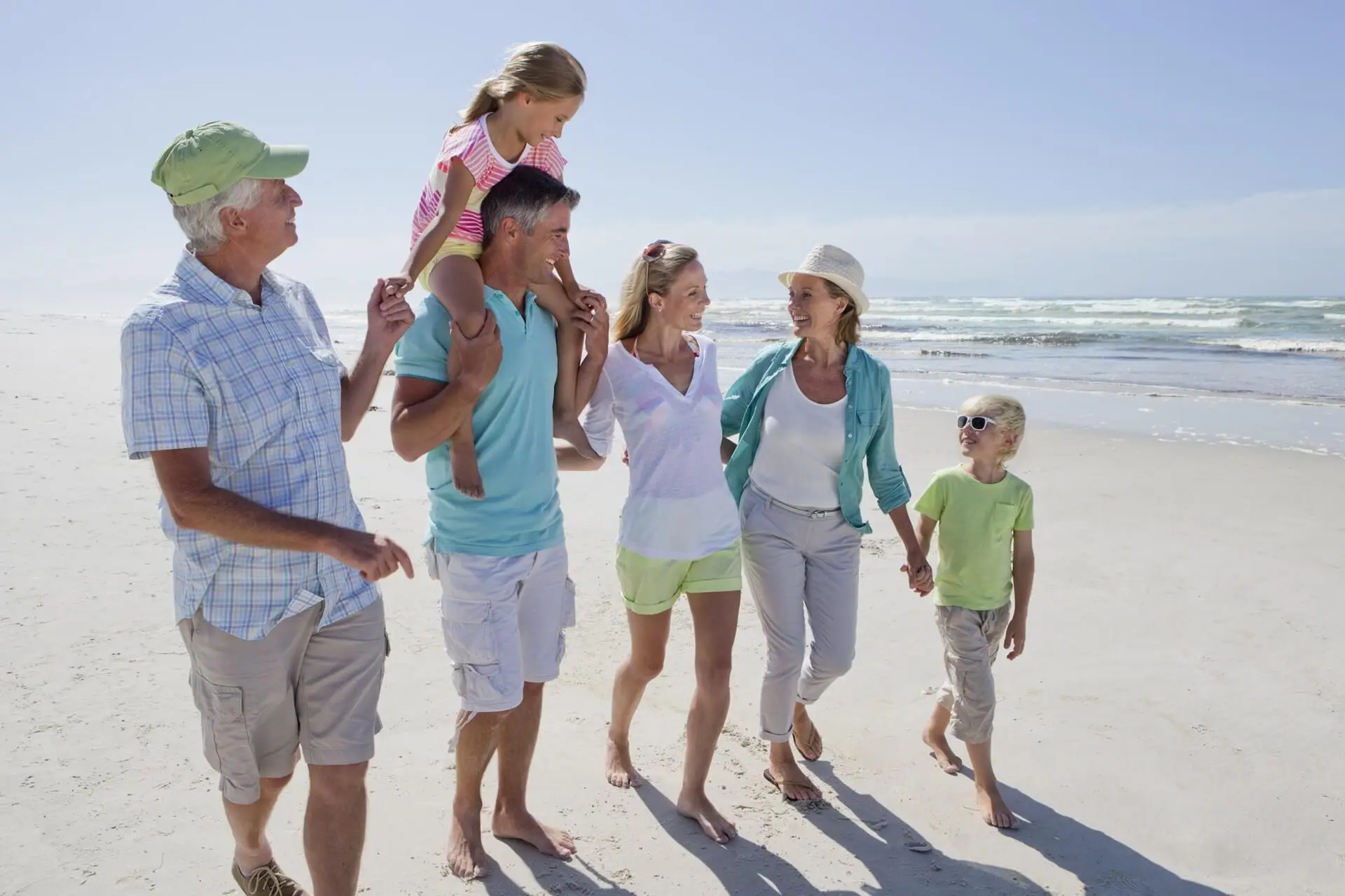 Eine Familie spaziert am Strand entlang.
