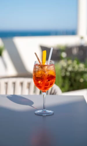 A chilled Aperol spritz garnished with an orange slice on a sunny patio.