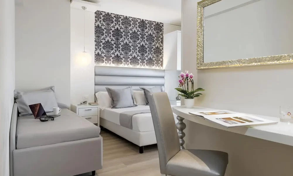 Moderner, eleganter Hotelraum mit stilvollen Tapeten, Doppelbett, Schreibtisch und Dekoration.