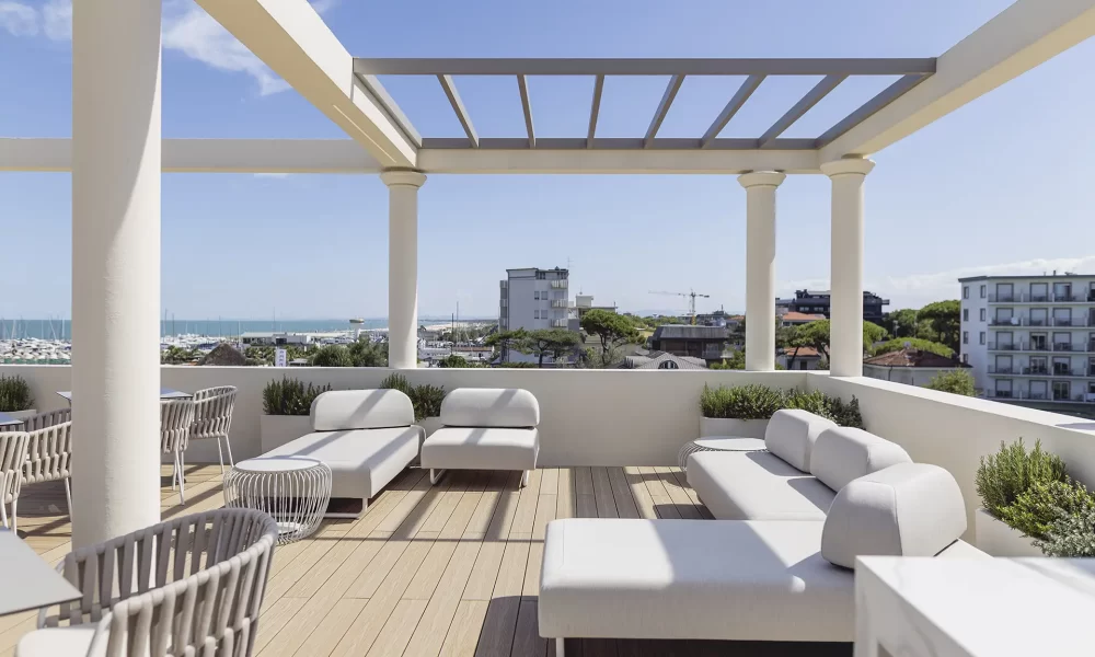 Terrazza moderna con vista sul mare, arredamento elegante e cielo sereno.